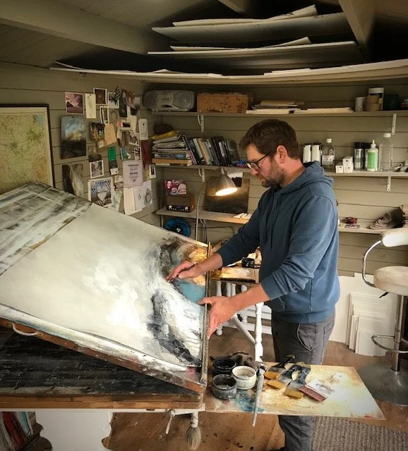 Contemporary British artist, Paul Denham, works on one of this landscape paintings in his art studio